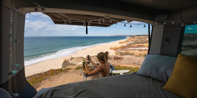 You can see from inside a camper a woman sitting next to the vehicle on the beach, preparing food. Bavarian Caribbean and the Caribbean in Europe – we present you the most beautiful spots
