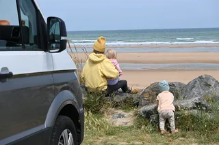 Mother with two children with camper on the beach in Holland