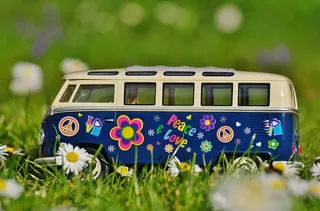 Small VW Bulli Toy with Hippie Flower Pattern in Grass